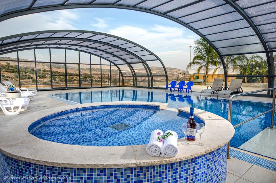 מתחם אירוח גדול עם בריכת שחיה מחוממת ומקורה מול נוף פתוח