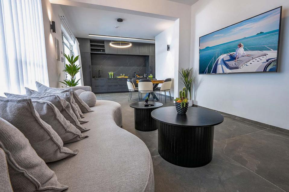 פינת ישיבה סלונית מרווחת מול מסך טלוויזיה גדול