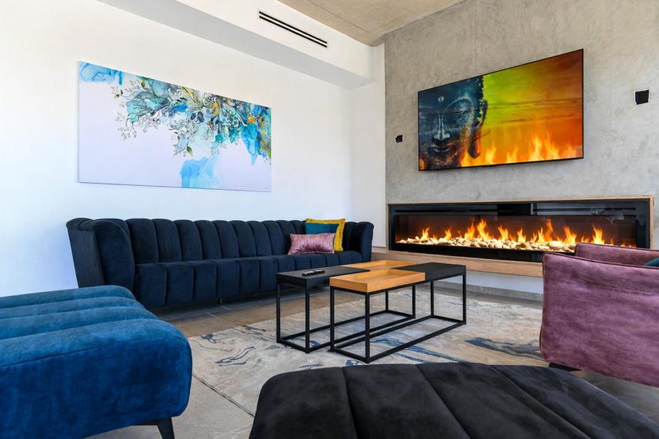 מסך טלוויזיה גדול וקמין חשמלי בסלון