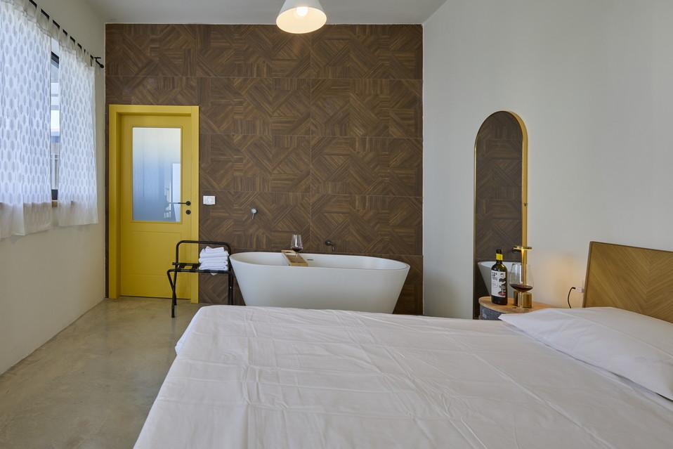 מיטה זוגית עם נוחות מקסימלית ולצידה אמבט זוגי מפנק