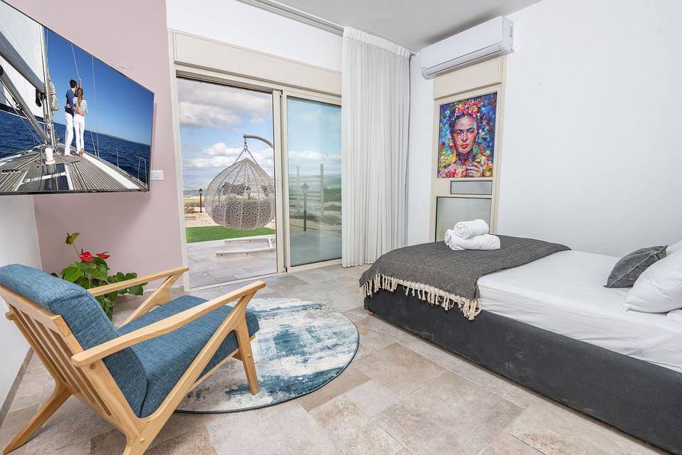 חדר שינה זוגי נעים ומרווח עם יציאה לחצר